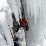 Some guy climbing a steep mixed route/pillar under the lower bridge.